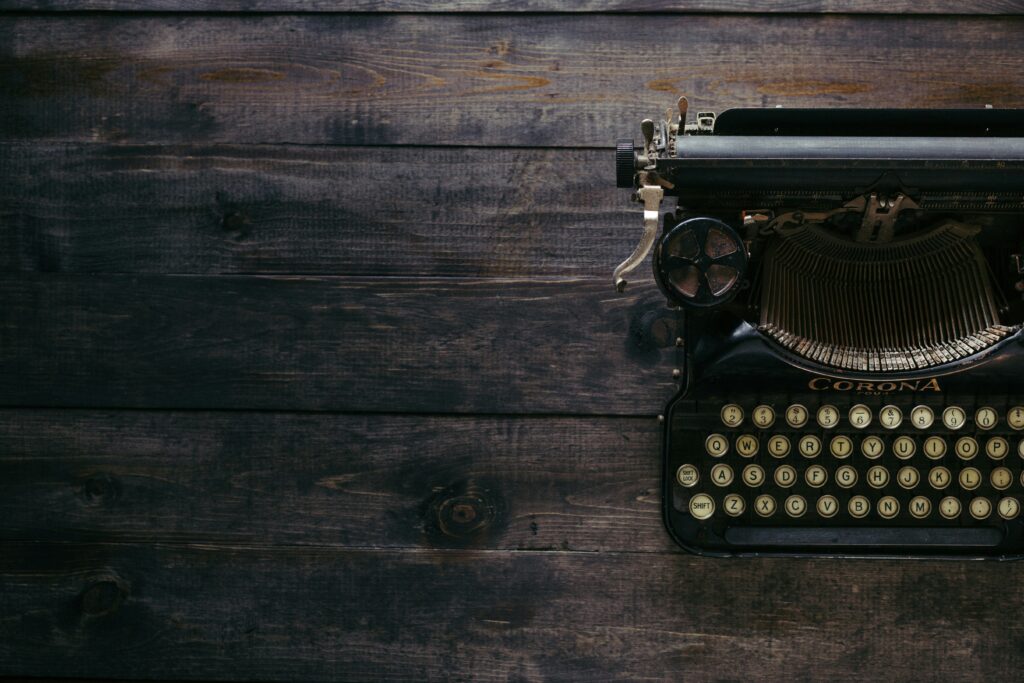 A black typewriter on a hardwood surface.
